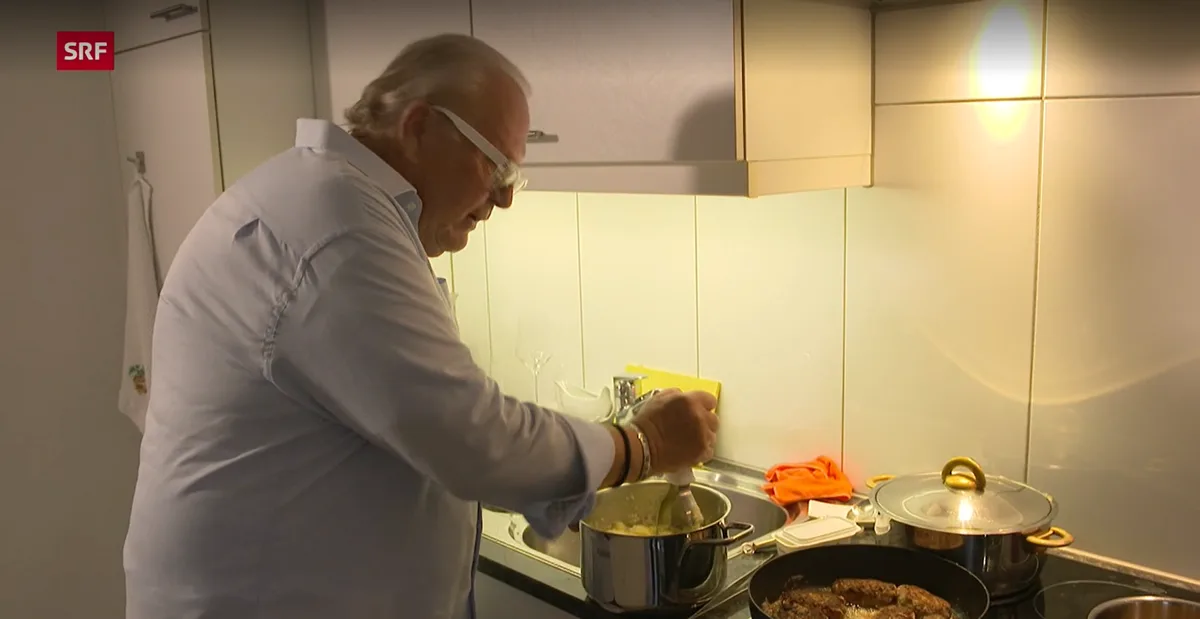Man sieht einen Mann beim Kochen.